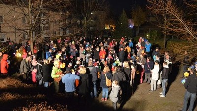Große Gruppe von Menschen geht nachts durch Park