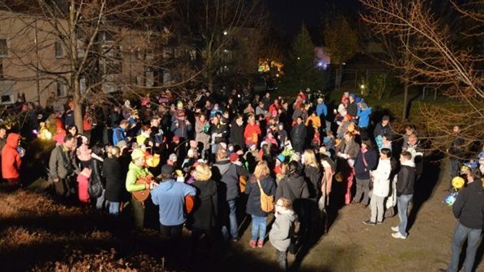 Große Gruppe von Menschen geht nachts durch Park