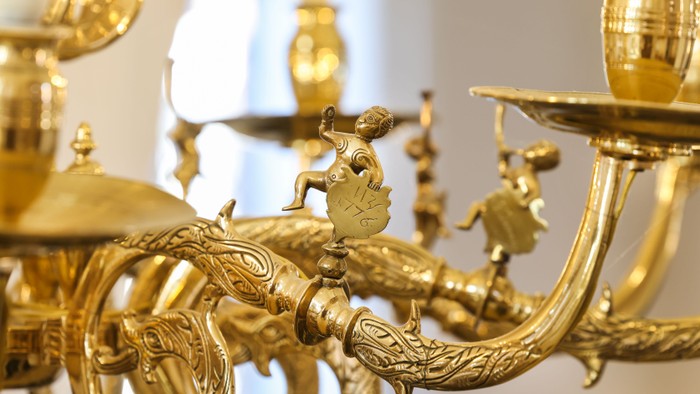 Guldfarvet lysstak med udvidede detaljer og figurer