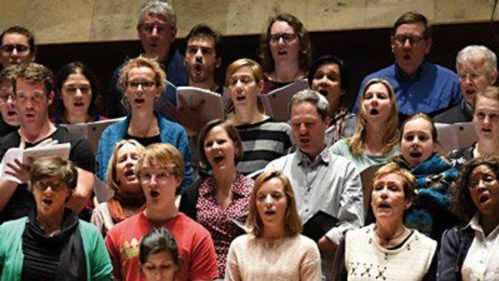 Eine große Gruppe von Menschen singt in einem Chor.