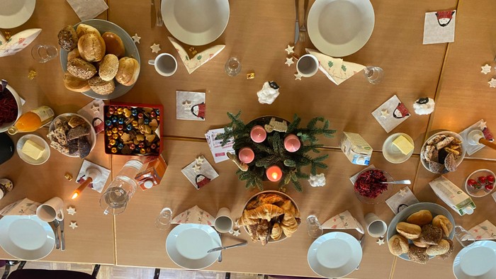 Weihnachtlicher Tisch mit Essen, Tellern und Kerzen