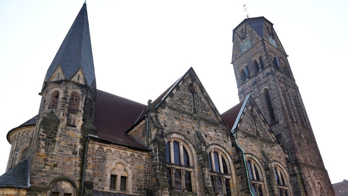 Historische Steinkirche mit hohen Türmen und filigranen gotischen Architekturdetails.