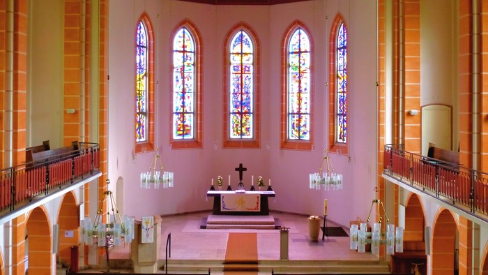 Die Kirche hat bunte Glasfenster und eine Empore