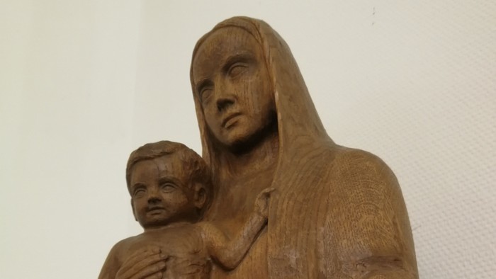 Holzskulptur einer Frau mit Kind an der Wand