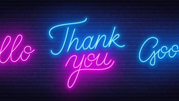 Neonschild mit den Worten „Hallo“, „Danke“ und „Auf Wiedersehen“ in leuchtendem Pink und Blau in verschnörkelter Schreibschrift.