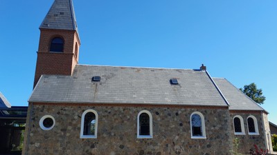 En stenkirke med tårn og tagvinduer.
