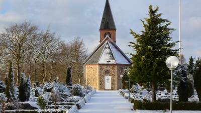 En lille kirke i sneklædt landskab