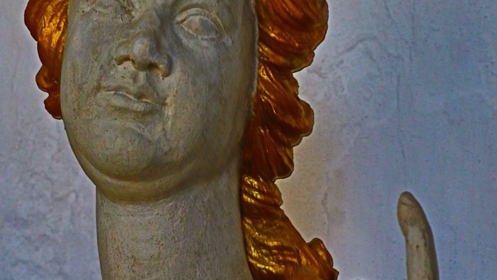 Guld og grøn statue af kvinde med vinges.
