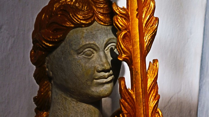 Guldstatue af kvinde med fjer.