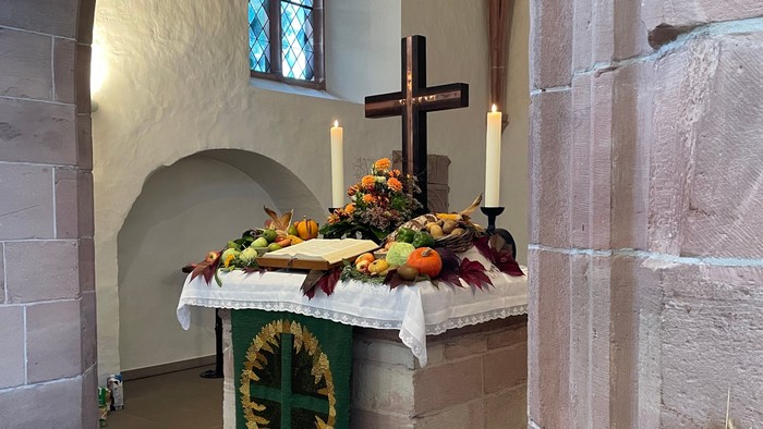 Altar in Kirche mit Kreuz, Kerzen und Blumen