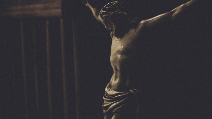 En skyggeagtig statue af Jesus Kristus på korset.