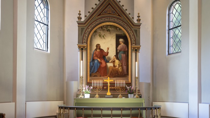 Alter i kirke med maleri og lysstake