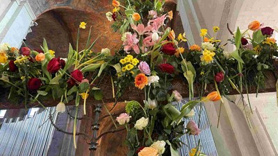 Prachtvolle Blumenarrangements in Kirche mit bunten Blumen und grünen Blättern