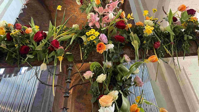 Prachtvolle Blumenarrangements in Kirche mit bunten Blumen und grünen Blättern
