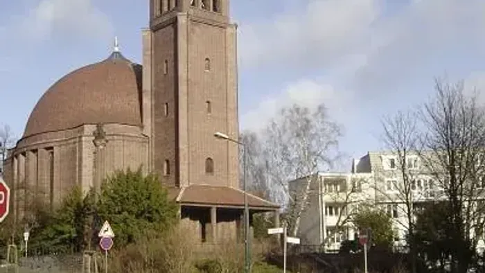Kirche St. Georg mit rundem Kuppeldach und kegelförmiger Turmspitze.