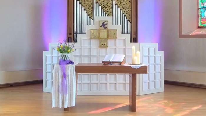 Ein Altar in einer Kirche mit Blumen, Kerzen und einem Buch