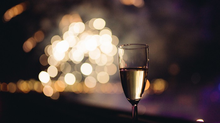 Glas champagne med fyrværkeri i baggrunden. 