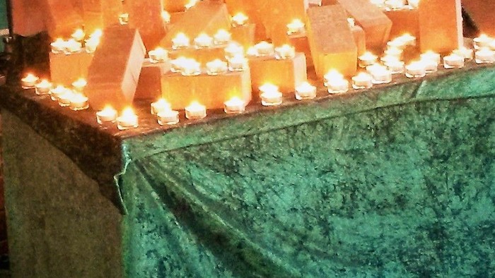Viele Kerzen auf einem Tisch mit grüner Tischdecke