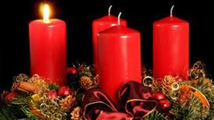 Drei brennende rote Kerzen auf Weihnachtsdekoration