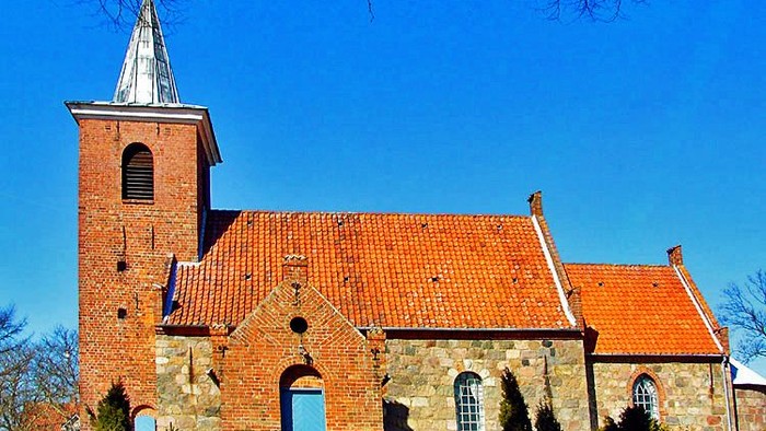 Røde kirke med spir med blå himmel
