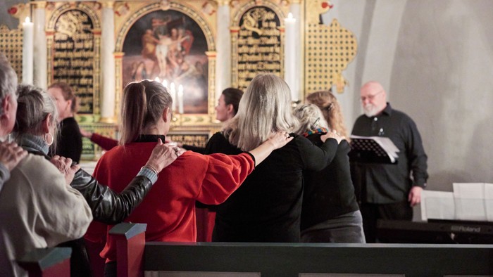 En gruppe af mennesker deltager i en religiøs ceremonie i en kirke.