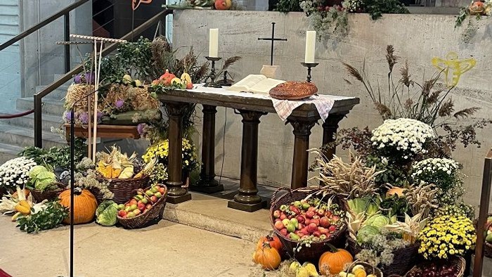 Prachtvolle Kirchendekoration mit Blumen, Kürbissen und Kerzen