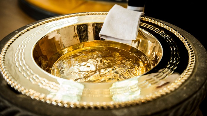 En smuk og poleret sølvbåde med en hvid klæde og en skøn skål.