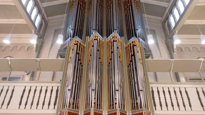 Stor kirkeorgel med guldakcentuer i indre del af kirke