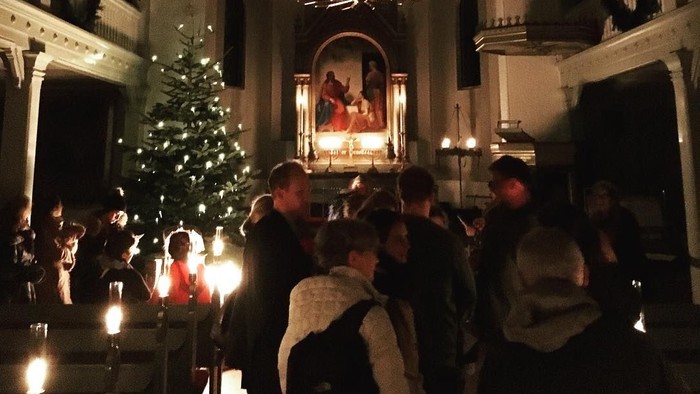 En kirke med juletræ og folk ved alteret