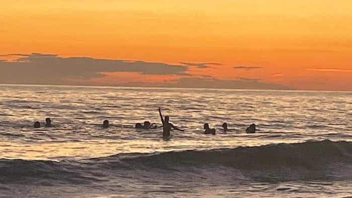 Surfer bei Sonnenuntergang am Meer