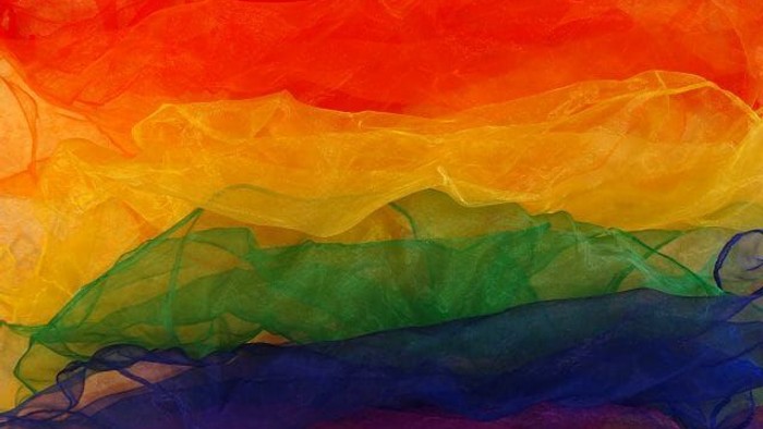 Lebendiger, fließender regenbogenfarbener Stoff mit sanften Farbverläufen zwischen den Nuancen.