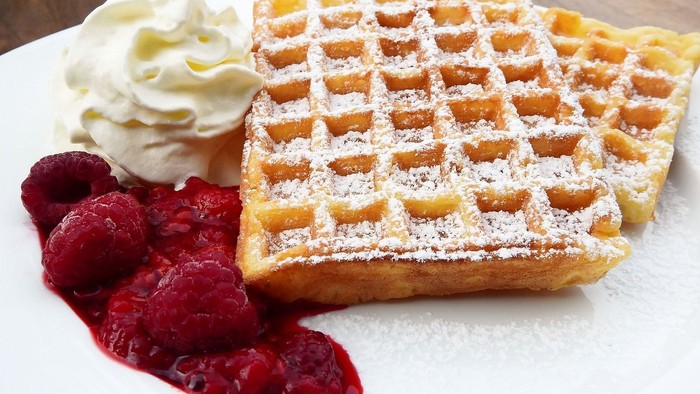 Waffeln mit Sahne und Erdbeeren auf einem Teller