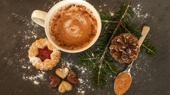 Weihnachtliche Kaffeetafel mit Kaffee, Keksen und Tannenzapfen