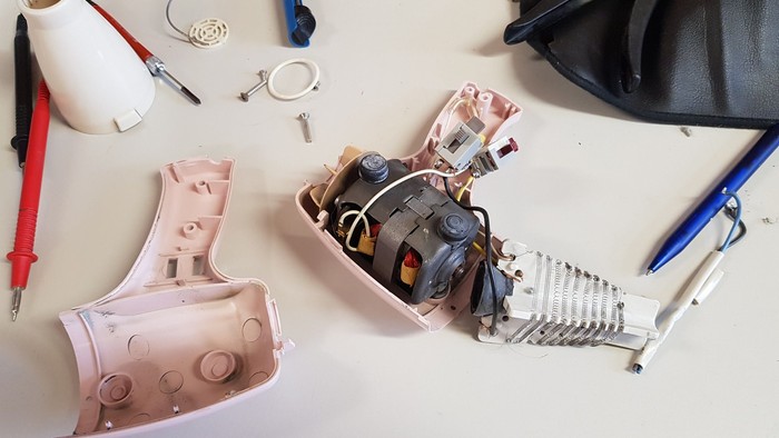 Ein defekter Föhn mit Werkzeug auf einem Tisch