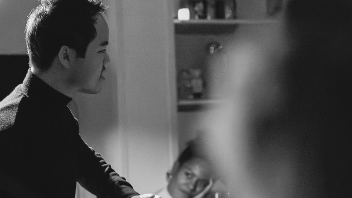 Mand spiser med en lille pige på skørtet.