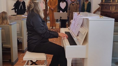 Kvinde spiller piano i kirke