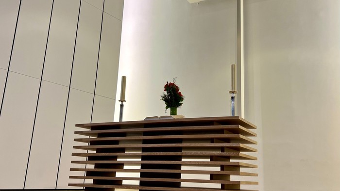 Ein moderner Altar in einer Kirche mit Kreuz und Blumenstrauß