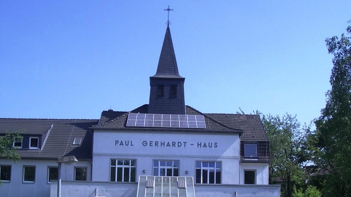 Das Paul Gerhardt Haus mit Kirche und Solarpanels vor blauem Himmel