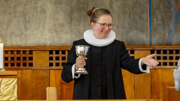 En præst holder en kælenav i kirke.