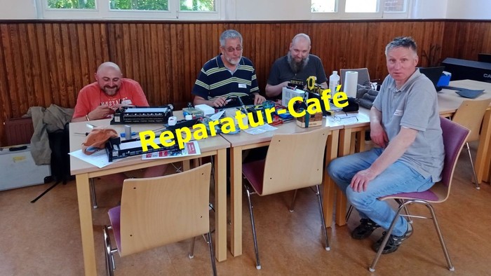 Mitarbeiter vom Reparatur-Café bei der Arbeit im Saal neben der Kirche.