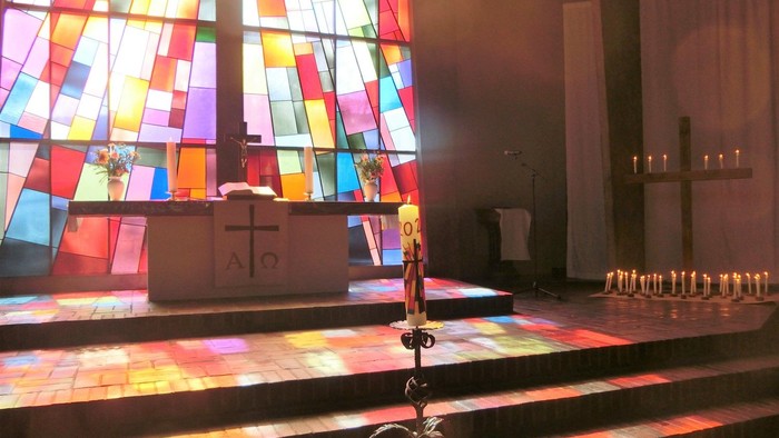 Bunte Kirchenfenster erleuchten den Altar in einer Kirche