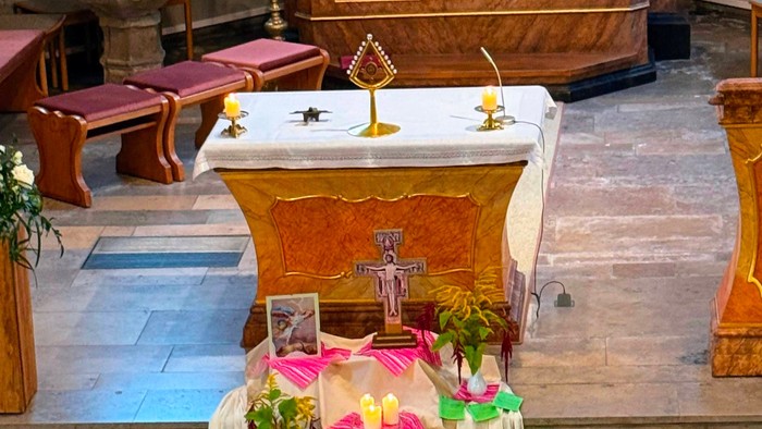 Die Kirche ist mit grünen und rosa Blumen für eine Feier dekoriert