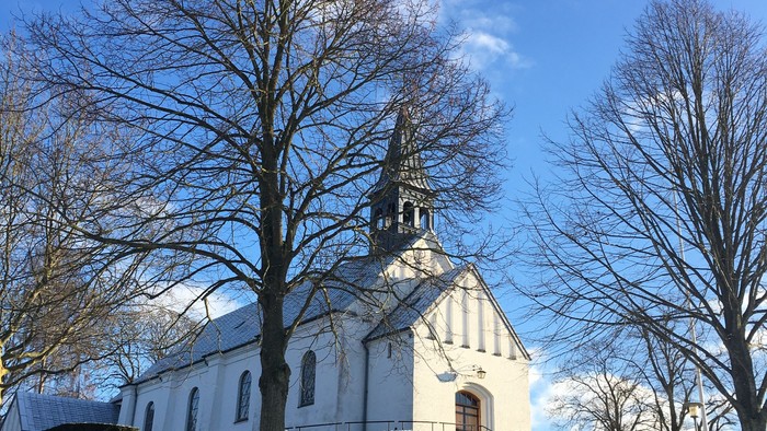 Hvid kirke omgivet af nøgne træer