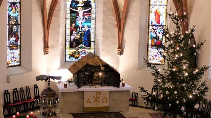 Kircheninneres mit Buntglasfenstern, Altar und Weihnachtsbaum
