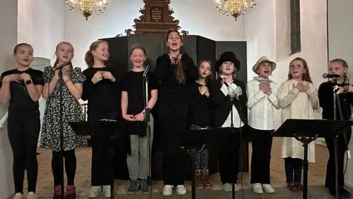 Otte børn synger i kirken.