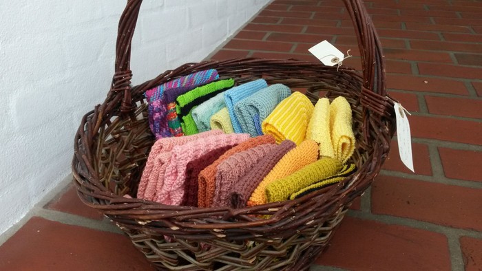 En vikket kurv med farvede skålske, placeret på en murstenet gulv