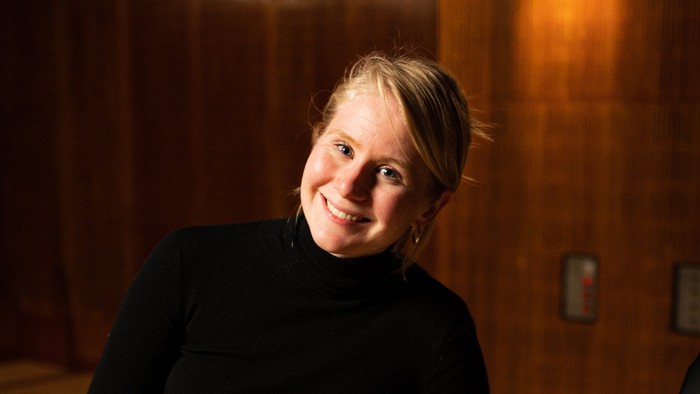 Kvinde ved piano i mørkt rum