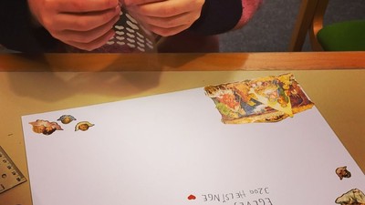En person sætter en stempel på et hvidt brev.
