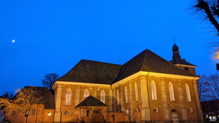 Grosses, beleuchtetes Kirchengebäude bei Nacht mit klarem Himmel