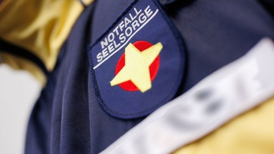 Das Bild zeigt ein Abzeichen mit einem Stern und Text auf einer Uniform.